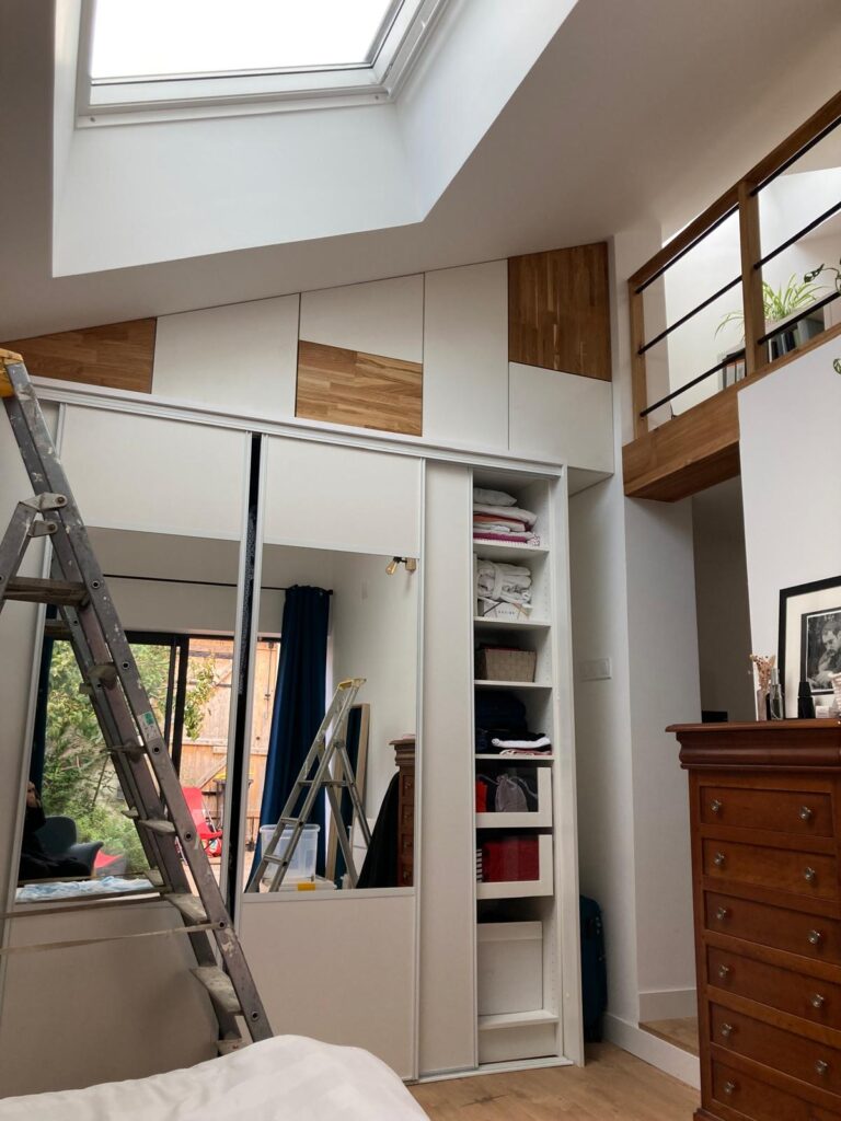 Aménagement de mezzanine avec dressing sur-mesure sous pente, fenêtre de toit Velux et garde-corps bois, réalisation Garcia Rénovation 49.