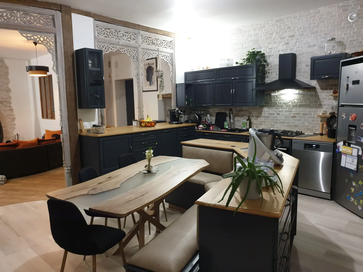 Cuisine équipée noire et bois avec table rivière sur-mesure, parement briques et arche sculptée, réalisation Garcia Rénovation Intérieur Angers.