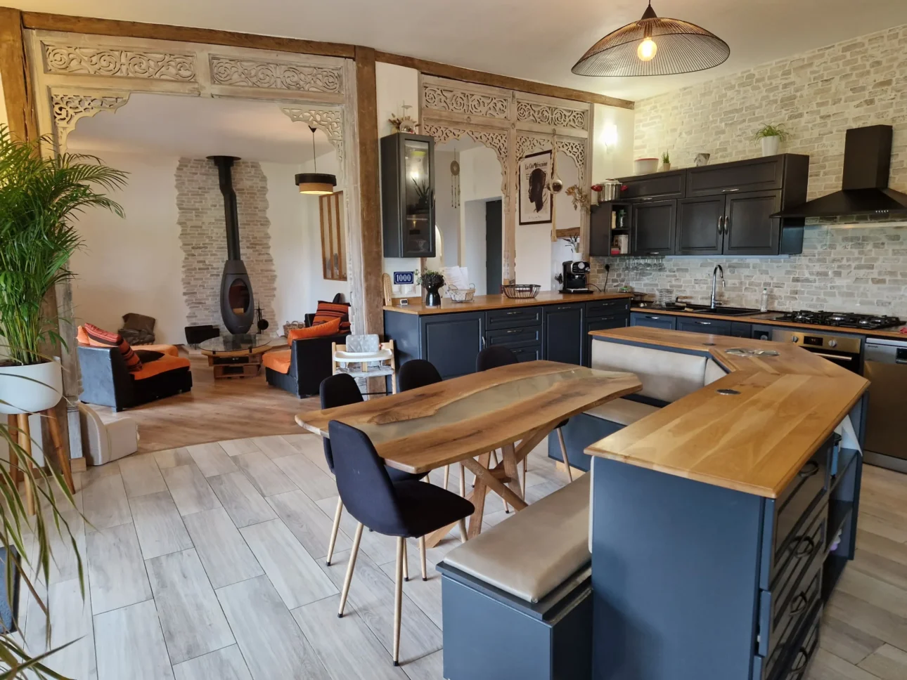 Îlot de cuisine sur-mesure avec bar, banquette intégrée et plan de travail en bois massif, conception par Garcia Rénovation Intérieur 49.