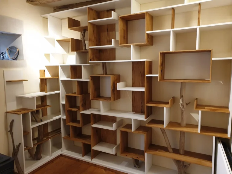 Bibliothèque sur mesure haut de gamme avec intégration de branches de bois brut et casiers blancs asymétriques à Angers.