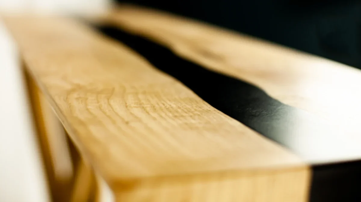 Détail d'une console river table en bois massif et résine époxy noire avec finition chute d'eau (waterfall) par Garcia Collection.