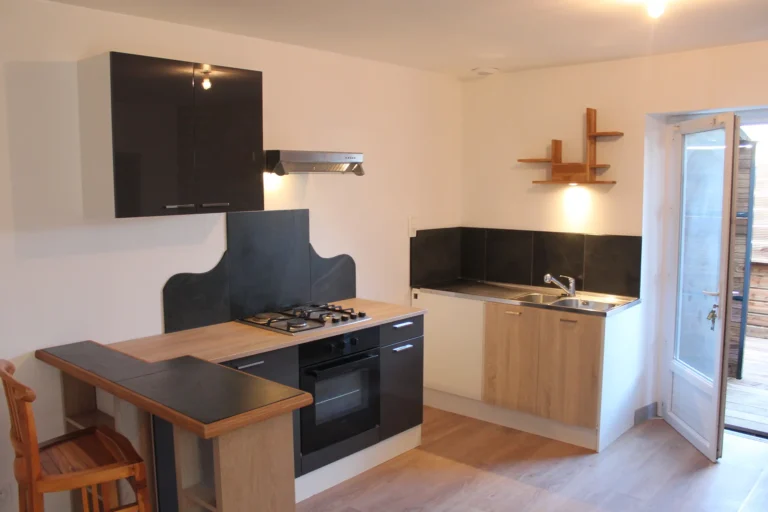 Installation d'une cuisine moderne avec façades noires, plan de travail en bois clair et étagère artisanale sur mesure à Angers.
