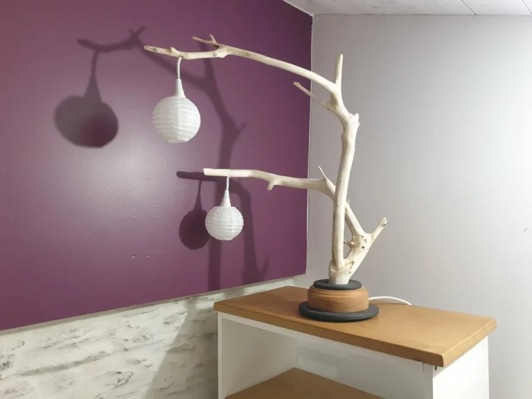 Lampe de salon artisanale en bois flotté blanc avec ombres portées décoratives sur mur prune, création Garcia Collection à Angers.