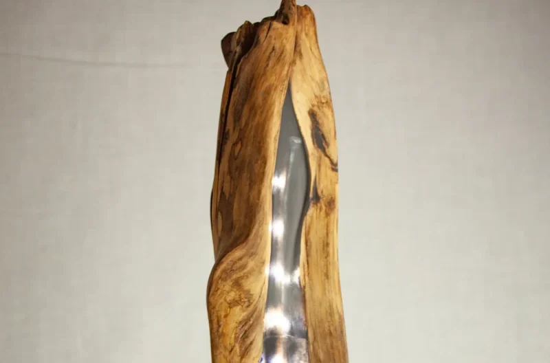 Lampe totem artisanale allumée, le bois flotté creux diffuse une lumière LED chaleureuse le long de ses formes naturelles, création unique.