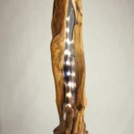 Lampe totem artisanale allumée, le bois flotté creux diffuse une lumière LED chaleureuse le long de ses formes naturelles, création unique.