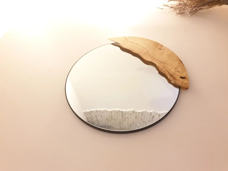 Miroir mural rond au design unique avec insertion organique sculptée en bois de chêne massif, réalisé sur mesure par Garcia Rénovation à Angers.