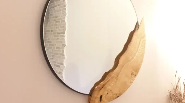 Miroir mural rond au design unique avec insertion organique sculptée en bois de chêne massif, réalisé sur mesure par Garcia Rénovation à Angers.