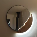 Miroir rond rétroéclairé avec bordure organique en bois massif sculpté, création artisanale Garcia Rénovation Angers.