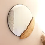 Miroir mural rond au design unique avec insertion organique sculptée en bois de chêne massif, réalisé sur mesure par Garcia Rénovation à Angers.