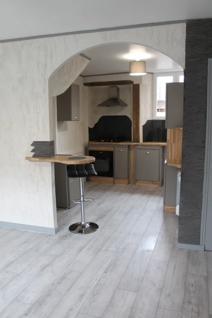 Rénovation complète d'un espace de vie ouvert avec cuisine moderne grise et comptoir bar arrondi, Garcia Rénovation Angers.