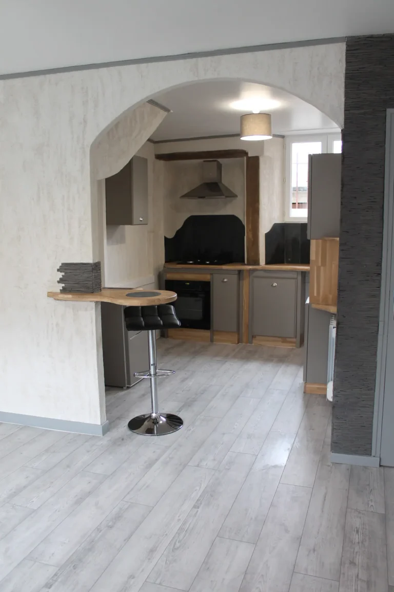 Rénovation complète d'un espace de vie ouvert avec cuisine moderne grise et comptoir bar arrondi, Garcia Rénovation Angers.