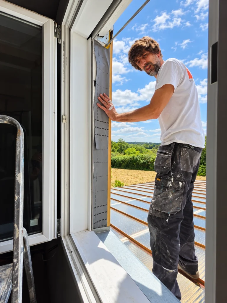 David Colorado pose une menuiserie lors d'un chantier de rénovation intérieure en Maine-et-Loire