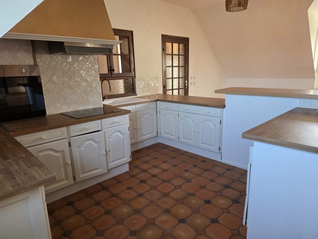 Cuisine mansardée après relooking : façades blanches, plan de travail bois et crédence en carreaux artisanaux